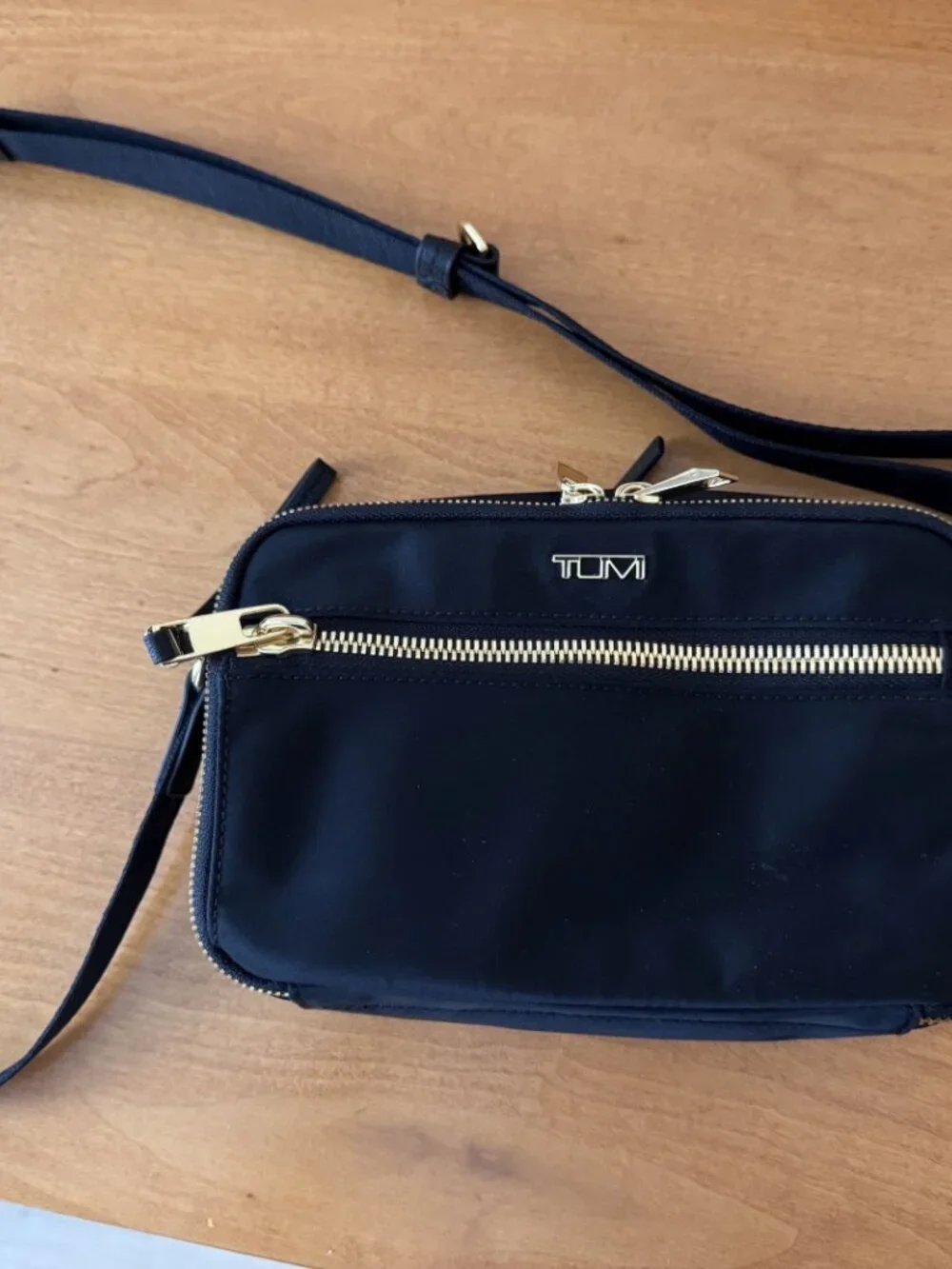 Authentic TUMI Voyageur Langley Crossbody in black with gold-tone hardware